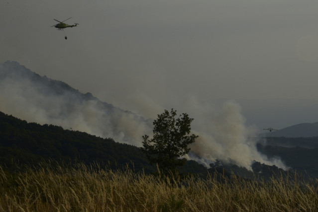 Un helicóptero tira agua sobre el fuego para extinguir el incendio, a 2 de agosto de 2025, en Vilardevós, Ourense, Galicia (España).