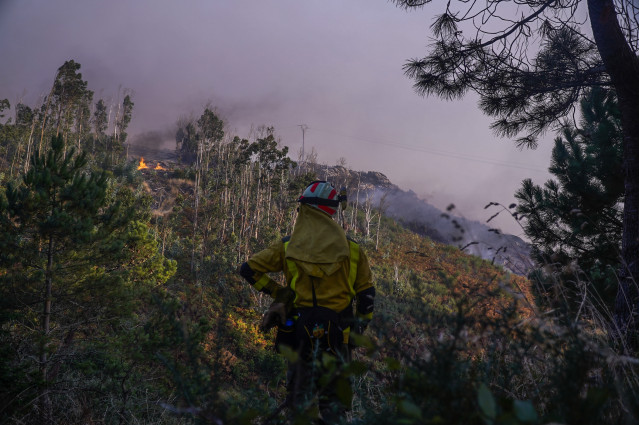 Un bombero observa el fuego, a 5 de agosto de 2025, en Ponteceso, A Coruña, Galicia (España).
