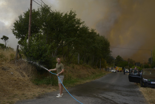 Una persona colabora en la extinción del incendio, a 12 de agosto de 2025, en Seixalbo, Ourense.