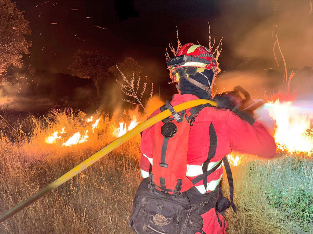 Una agente de la Unidad Militar de Emergencias (UME) trabaja en las labores de extinción del incendio, a 12 de agosto de 2025, en Tres Cantos, Madrid (España).