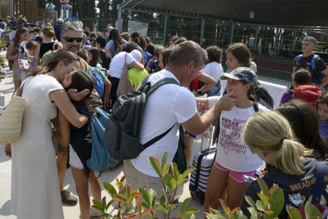Varios niños abrazan a familiares, en el parque acuático de Monterrei.