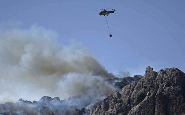 Medios terrestres y aéreos operan en el incendio declarado en el paraje Sierra de la Plata, cercano a la playa de Bolonia, a 11 de agosto de 2025, en Tarifa (Cádiz, Andalucía, España). La Junta de Andalucía ha activado la fase de emergencia en situación o