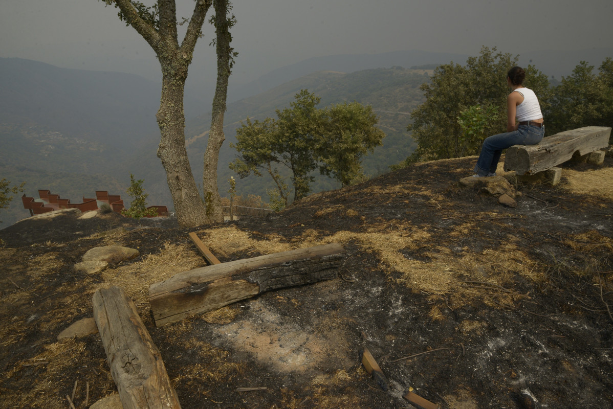 Varios vecinos observan sus fincas tras el paso del fuego, a 13 de agosto de 2025, en Somoza, Pobra de Trives, Ourense, Galicia (España).