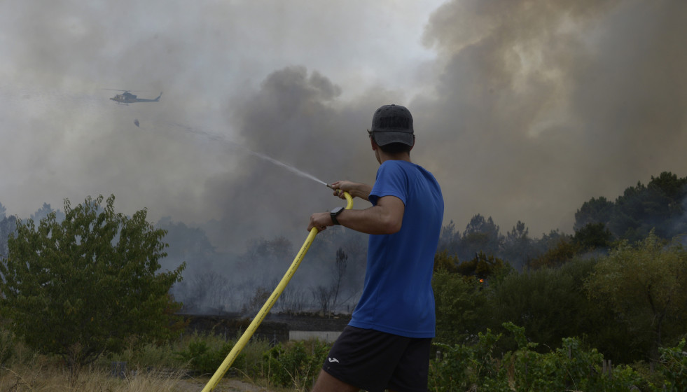 Extinción del incendio declarado a partir de la vía del tren en Seixalbo, en un terreno en el que ardieron varias colmenas
