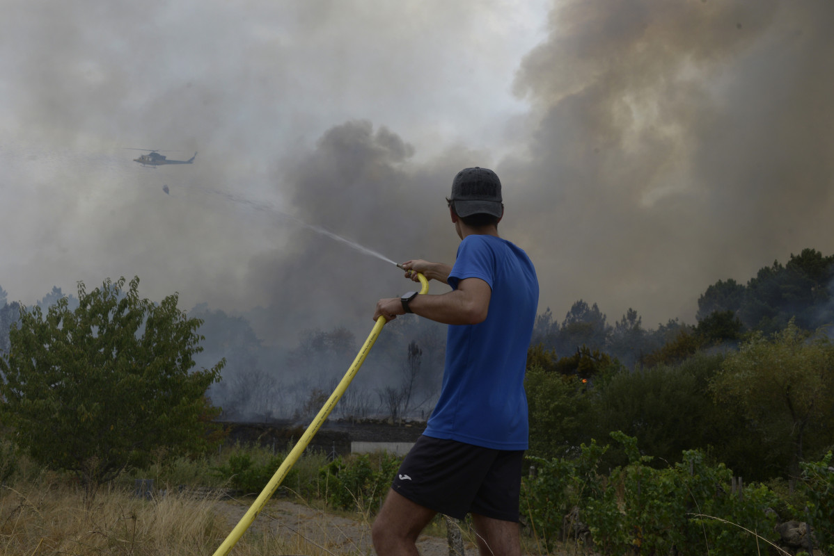 Extinción del incendio declarado a partir de la vía del tren en Seixalbo, en un terreno en el que ardieron varias colmenas