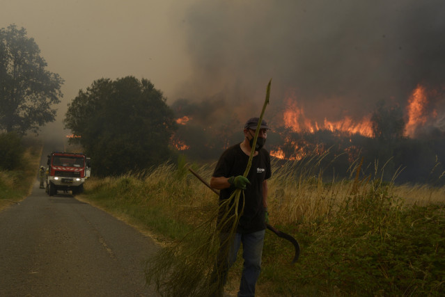 Vecinos y vecinas de Vilela mientras se acercan las llamas a la localidad, a 15 de agosto de 2025, en Vilela, Cualedro, Monterrei, Ourense, Galicia (España).