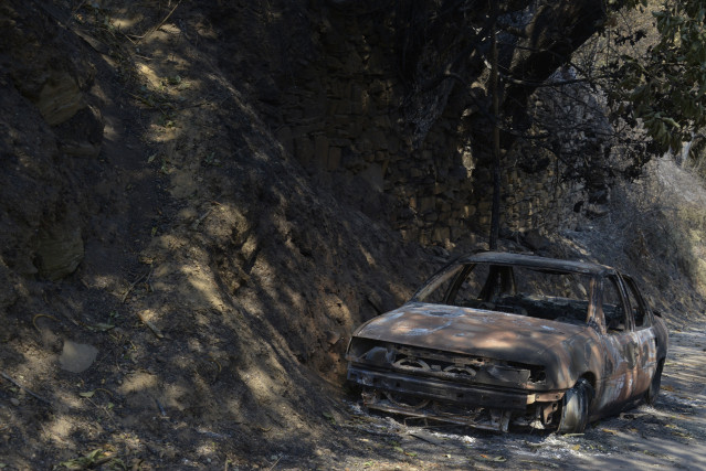 Un coche calcinado tras el incendio en San Vicente de Leira en Villamartín de Valdeorras, Ourense