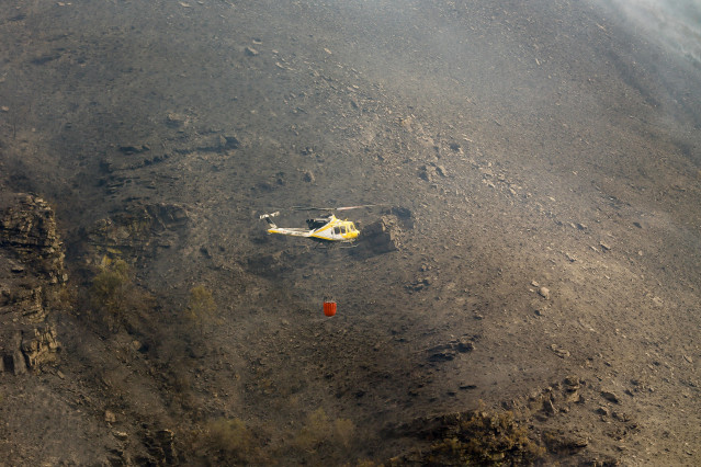 Un helicóptero colabora en las labores de extinción del incendio, a 19 de agosto de 2025, en Quiroga, Lugo