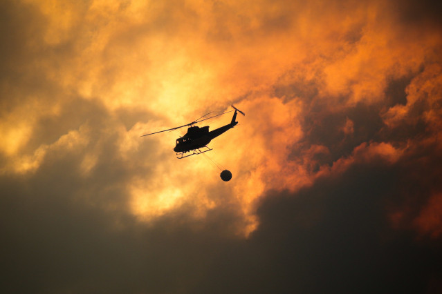Un helicóptero recoge agua para ayudar con las labores de extinción del incendio, a 26 de agosto de 2025, en Aguas Mestas, Lugo, Galicia (España).