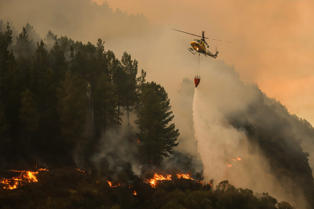 Un helicóptero suelta agua sobre el fuego, a 26 de agosto de 2025, en Covas, Lugo