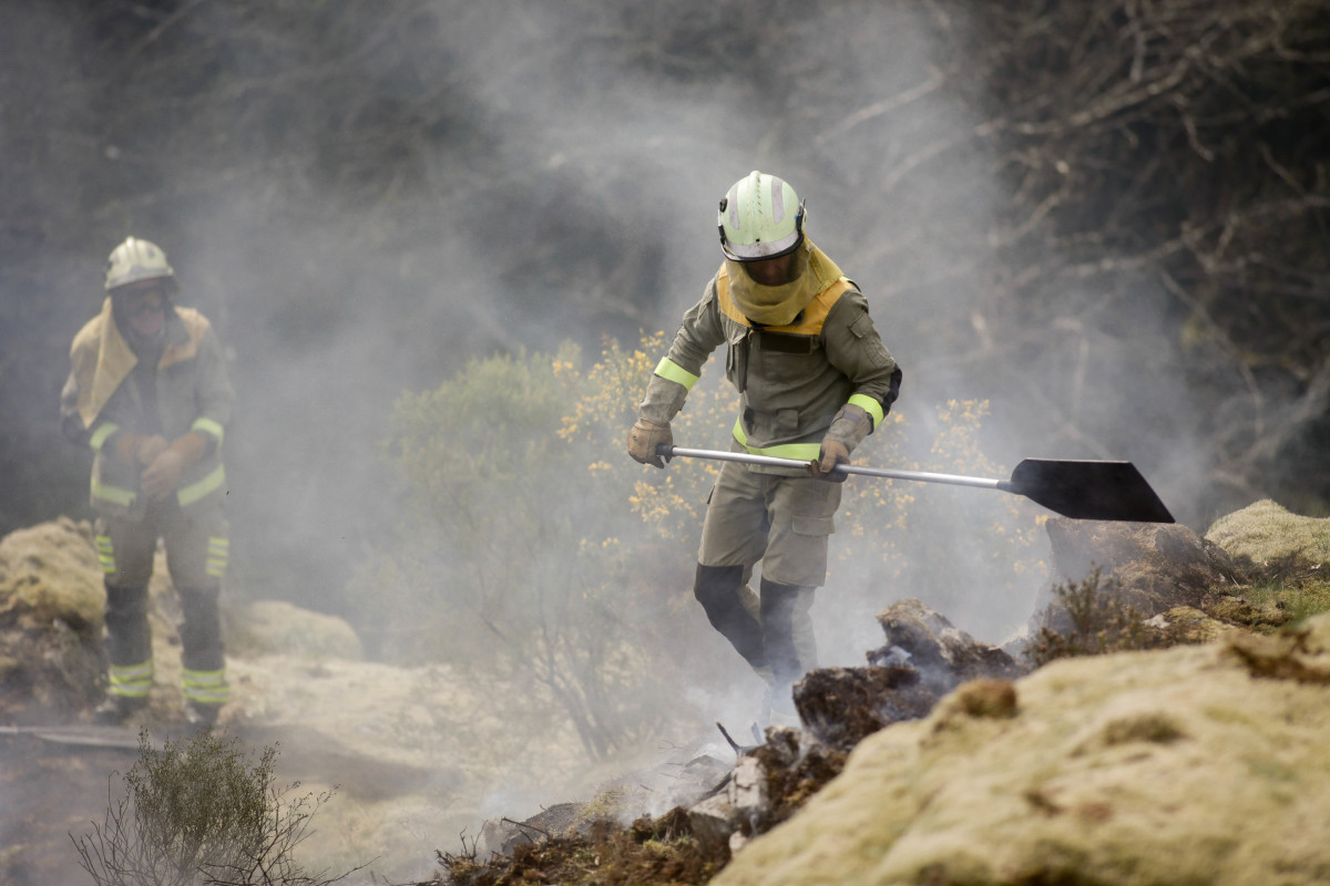 Archivo - Dos brigadistas forestales trabajan para extinguir las llamas en un incendio forestal