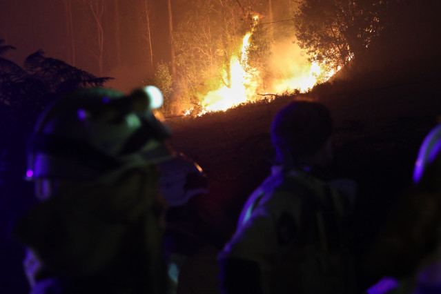 Bomberos trabajan en labores de extinción y control del fuego en la aldea de Rexa, a 15 de septiembre de 2024, en Barreiros, Lugo, Galicia (España). Cinco brigadistas han resultado heridos cuando participaban en las labores de extinción del incendio que p