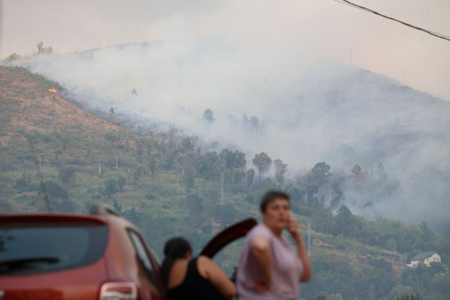 Vecinos ven el avance del fuego, a 25 de agosto de 2025, en A Pobra de Brollón, Lugo, Galicia (España).
