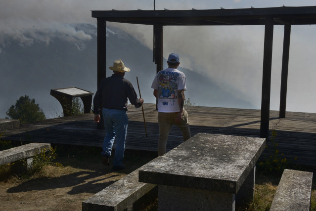 Varias personas observan el incendio desde el mirador de A Lampa en la aldea de Moura, a 19 de septiembre de 2025, en Nogueira de Ramuín, Ourense, Galicia (España).