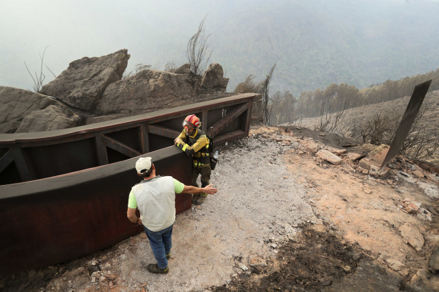 Un brigadistas forestal y un vecino de la zona hablan del terreno calcinado, a 20 de septiembre de 2025, en A Barca, Sober, Lugo, Galicia (España).