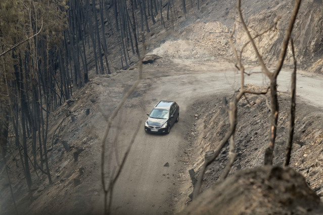 Un coche circula al lado del terreno calcinado, a 20 de septiembre de 2025, en A Barca, Sober, Lugo, Galicia (España).