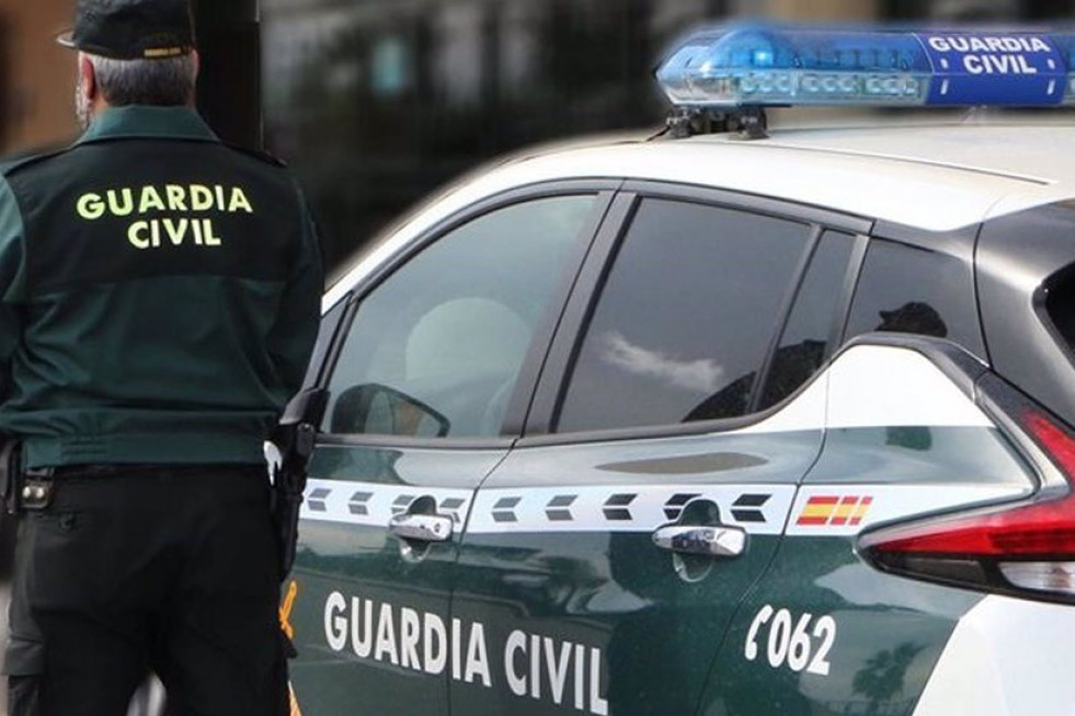 Un agente de la Guardia Civil junto a un vehículo oficial. Imagen de archivo.