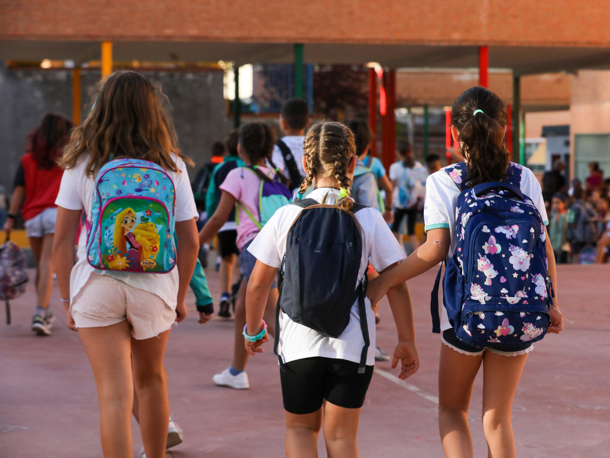Archivo - Tres niñas entran en el colegio.