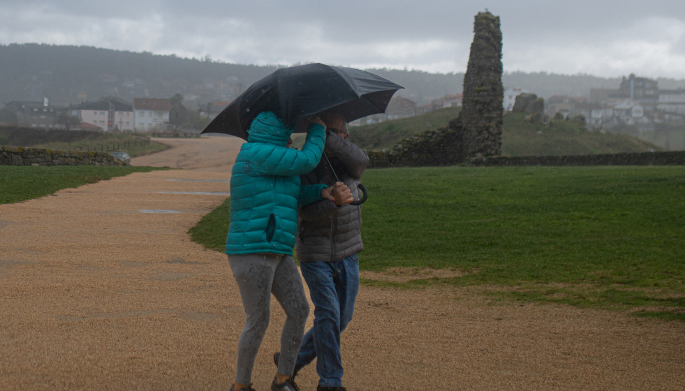 Archivo - Dos personas se protegen de la lluvia con un paraguas, en la playa de A Lanzada, a 5 de noviembre de 2023, en O Grove, Pontevedra, Galiciia.