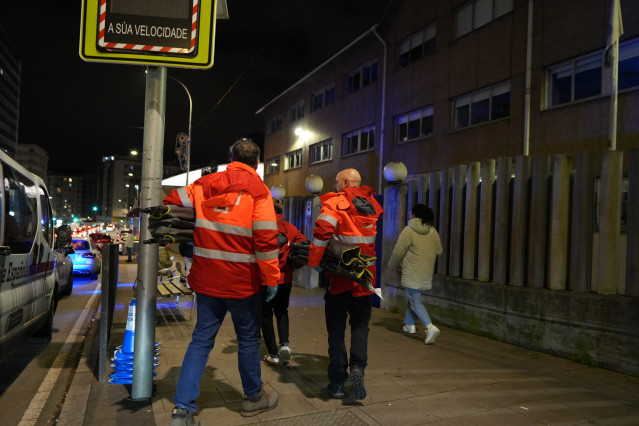 Miembros de Cruz Roja llevan camas para habilitar el polideportivo Sagrada Familia tras el incendio en un edificio en A Coruña