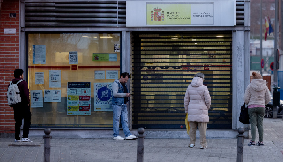 Archivo - Varias personas en la puerta de una oficina del SEPE.
