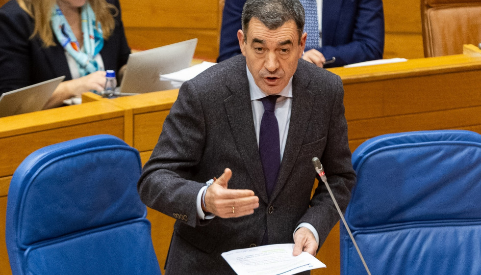 El conselleiro de Educación, Román Rodríguez, responde a una pregunta en el pleno del Parlamento de Galicia.