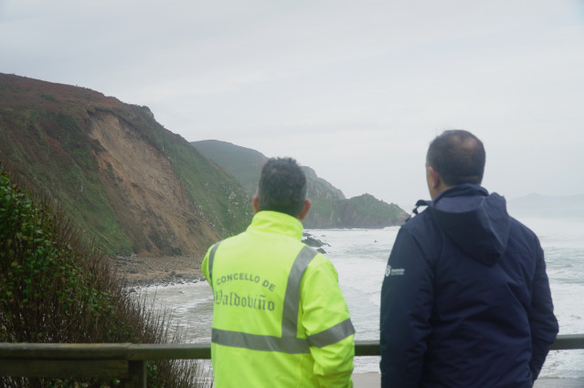 Dos personas observan los desprendimientos en los acantilados de Campelo, a 9 de diciembre de 2025, en Valdoviño