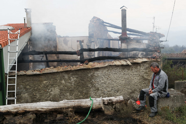 Archivo - Una persona junto a una casa calcinada, a 20 de septiembre de 2025, en Pantón, Lugo, Galicia (España). La conselleira do Medio Rural, María José Gómez, ha explicado que las llamas de este incendio forestal calcinaron varias casas y, aunque la si