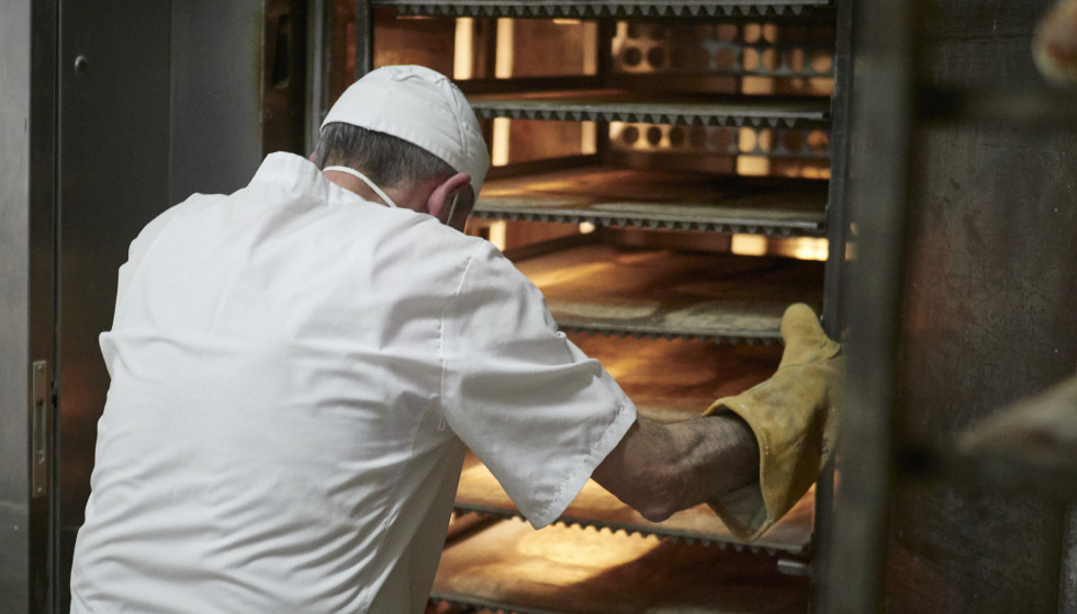 Archivo - Un trabajador protegido con mascarilla y guantes maneja bandejas para cocer el pan en el obrador panadería 'Panadero de Eugui' durante en el día 32 del estado de alarma, uno de los estable