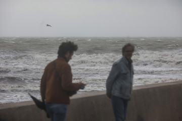 Archivo - Dos personas caminan en la Playa de la Malvarrosa, a 25 de marzo de 2022, en Valencia, Comunidad Valenciana-