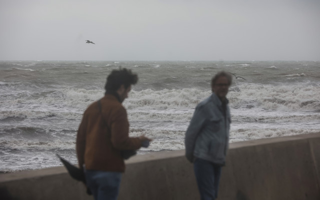 Archivo - Dos personas caminan en la Playa de la Malvarrosa, a 25 de marzo de 2022, en Valencia, Comunidad Valenciana-