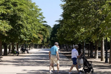 Archivo - Abuelos  paseando a su nieto.