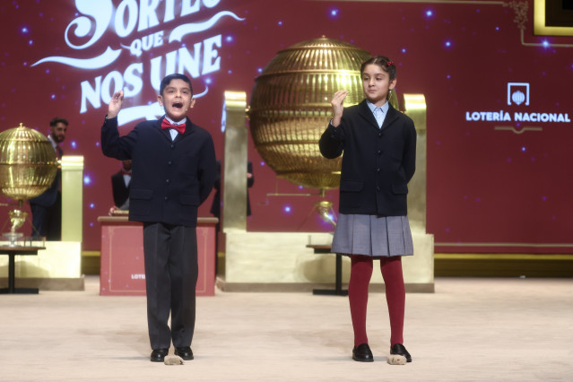 Dos niños del Colegio de San Ildefonso cantan el tercer premio de la Lotería de Navidad