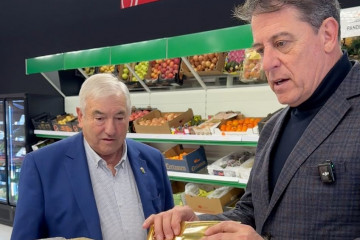 El secretario xeral del PSdeG, José Ramón Gómez Besteiro, en el supermercado municipal de Pol (Lugo) junto al alcalde de la localidad, Lino Rodríguez.