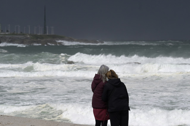 Archivo - Dos mujeres observan las olas durante el frente meteorológico, a 23 de febrero de 2024, en A Coruña, Galicia (España)