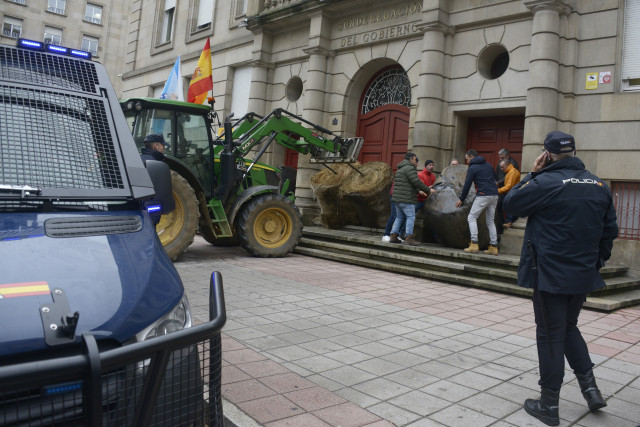 Un tractor deja bala de paja, frente a la Subdelegación del Gobierno en Orense, a 7 de enero de 2026, en Orense, Galicia (España). Agricultores y ganaderos ha iniciado una nueva jornada de protestas en rechazo al acuerdo de libre comercio UE-Mercosur