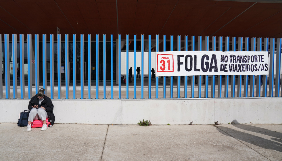 Archivo - Una mujer al lado de un cartel en la huelga de transporte