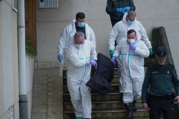 Operarios que participan en la retirada de basura y de un cadáver en una vivienda de Oleiros (A Coruña)