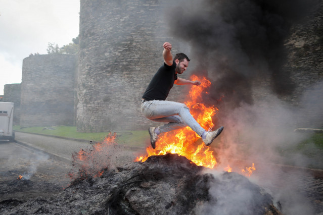 Hoguera de manifestantes de la tractorada que rodea la Muralla de Lugo desde el pasado lunes, frente a la Delegación de la Xunta de Galicia en Lugo, a 14 de enero de 2026, en Lugo, Galicia (España). Los ganaderos y agricultores gallegos continúan en pie d