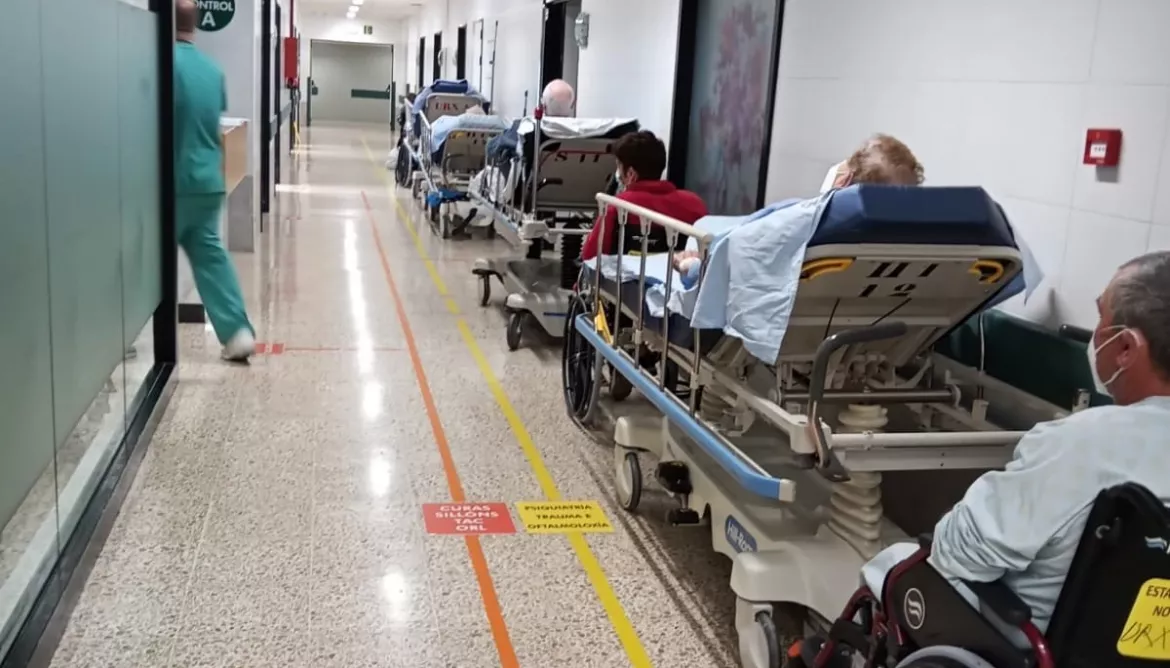 Pacientes con ingreso firmado esperando en el pasillo de las urgencias de Santiago a una cam