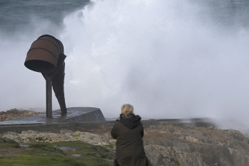 Archivo - Varias personas observan el oleaje en los alrededores de la Torre de Hércules.