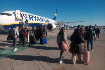 Archivo - Pasajeros de un vuelo de Ryanair suben a bordo de un avión estacionado en el aeropuerto de Sevilla.