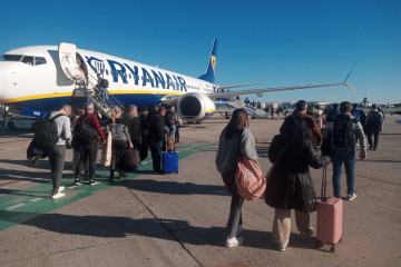 Archivo - Pasajeros de un vuelo de Ryanair suben a bordo de un avión estacionado en el aeropuerto de Sevilla.