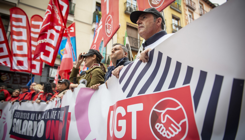 Archivo - Un grupo de personas sostiene banderas y una pancarta durante una movilización convocada por CCOO y UGT desde Puerta de Toledo, a 3 de noviembre de 2022, en Madrid (España). CCOO y UGT mov