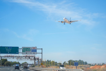Archivo - Un avión sobrevuela la autovía A-4 antes de aterrizar en el aeropuerto de Sevilla