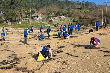 Voluntarios limpiando los plásticos acumulados en la playa de Area de Bon