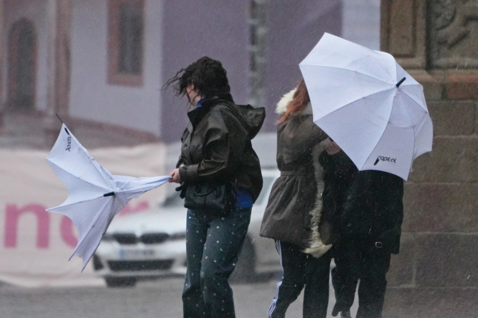 Turistas desarboladas por el temporal durante un episodio de mal tiempo en la Praza do Obradoiro de Santiago