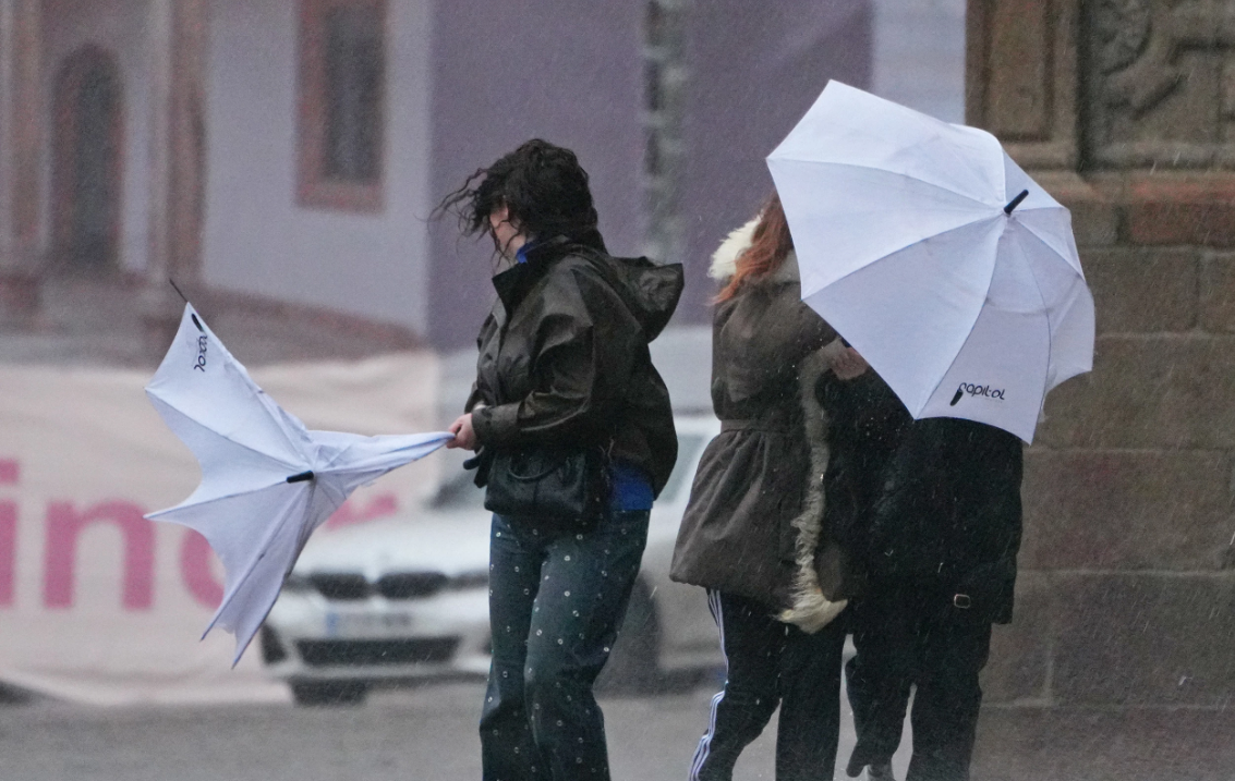 Turistas desarboladas por el temporal durante un episodio de mal tiempo en la Praza do Obradoiro de Santiago