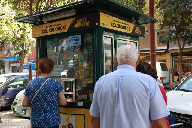 Archivo - Varias personas junto a un quiosco se disponen a comprar un cupón de alguno de los sorteos de la Organización Nacional de Ciegos Españoles (ONCE)