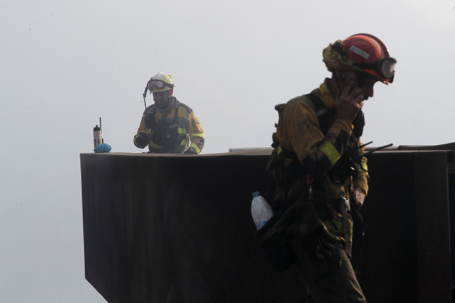 Archivo - Dos brigadistas forestales observan el terreno calcinado, a 20 de septiembre de 2025, en A Barca, Sober, Lugo, Galicia (España).